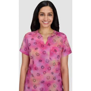 A pink short-sleeve top featuring a pattern of various smiley faces, with a relaxed neckline and a light fabric.