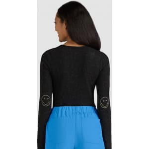 A black long-sleeve top featuring smiley face designs on the elbows, paired with blue bottoms.