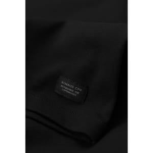 A black t-shirt with a label featuring a logo. The fabric appears smooth and soft.
