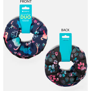 A duo set of printed scrunchies in dark fabric featuring colourful animal patterns and a branding tag.