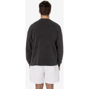 A man wearing a grey garment dye heavy thermal crewneck, viewed from the back, paired with white shorts.