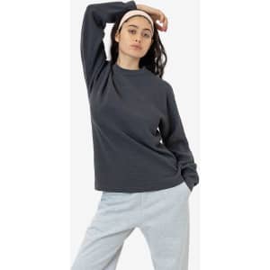 A model poses in a dark grey heavy thermal crewneck jumper paired with light grey pants.