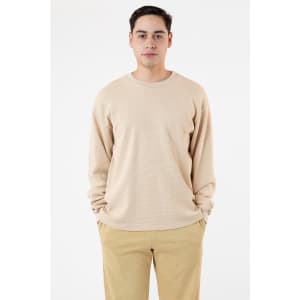 A light beige garment dye heavy thermal crewneck sweater, displayed on a model with relaxed fit pants.
