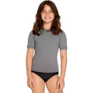 A grey youth short sleeve rashie with UPF 50+ protection, featuring a logo, paired with black swim bottoms.