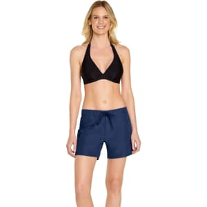 A model wearing navy women's cargo board shorts with a black bikini top. The shorts feature a drawstring waist and have branding.