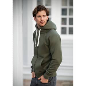 A man wearing an olive green hoodie with a front pocket and drawstring hood, featuring a logo.