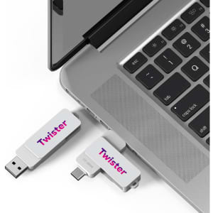 A Twister Type-C flash drive in silver is plugged into a laptop, showcasing a sleek design and branding.
