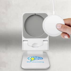 A white magnetic wireless charger with a logo, featuring a round charging pad and a hand holding a device.