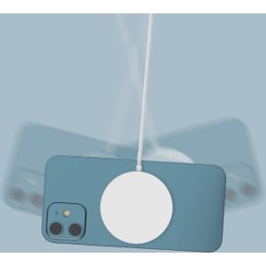 A white magnetic wireless charger is attached to a blue phone on a light blue background.