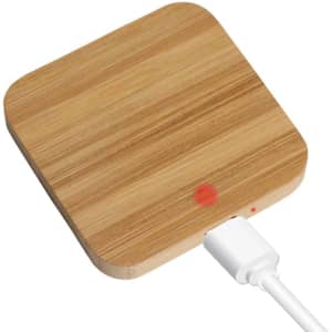 A square bamboo wireless charger in a natural wood finish with a white charging cable connected.