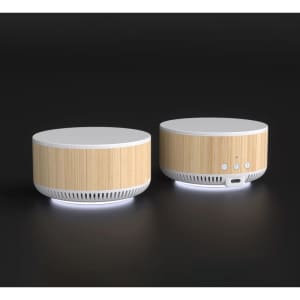 A wireless charging speaker with a bamboo finish and white accents, featuring buttons and a charging port on the side.