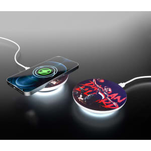 A round, wireless charger with a colourful design and a connected smartphone, featuring a glowing edge.