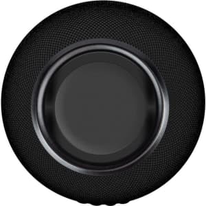 A black wireless charging speaker with a textured surface and a smooth centre, featuring a logo on the side.