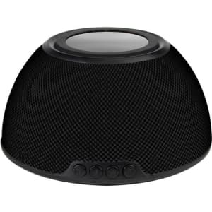 A black wireless charging speaker with a textured surface and control buttons on the front.