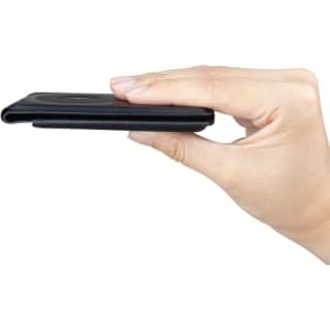 A black magnetic card wallet with a slim profile, being held in a hand against a white background.