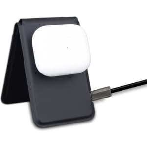 A black magnetic card wallet and wireless charging stand holding white wireless earbuds, connected by a charging cable.