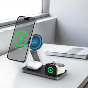 A magnetic, 3-in-1 wireless charging station in black, featuring a phone, AirPods, and an Apple Watch on display.