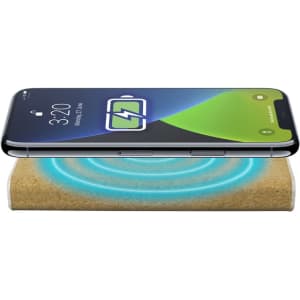 A wireless power bank with a natural finish, displaying a smartphone charging on top. It has a logo visible.