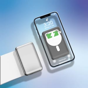 A silver power bank sits next to a smartphone, displaying a vibrant blue and green logo.