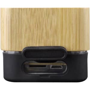 A wireless speaker with a bamboo exterior and a black base, featuring ports for connections.
