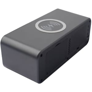 A black wireless charging speaker with a circular charging area on top and ventilation slots on the sides.