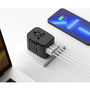 A black travel adaptor with multiple ports sits on a surface next to a smartphone, connected to various cables.