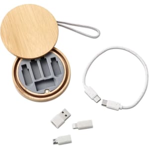A bamboo charging cable kit containing a white charging cable and multiple connectors in a circular case.
