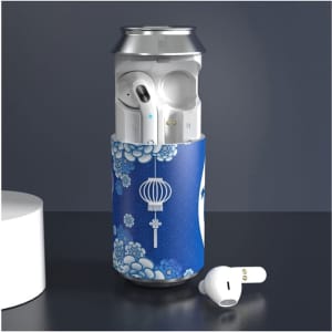 A blue-patterned can cooler with white Cannery TWS earbuds partially visible inside, alongside a white earbud on a countertop.