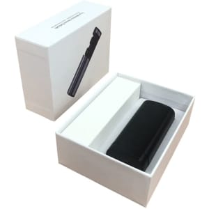 A black charging case for earbuds sits inside a white box, featuring a sleek design and minimalistic packaging.