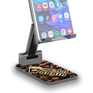 A foldable phone stand with a black and silver design, featuring a coffee-themed base and a logo on its surface.