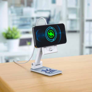A white foldable phone stand with a smartphone secured in place, displayed on a wooden surface.