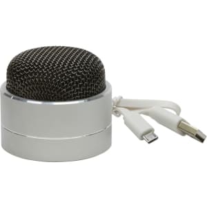 A compact silver Bluetooth speaker with a mesh grille and attached charging cables.