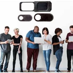 A set of three black webcam covers displayed above a group of people using various devices, including laptops and smartphones.
