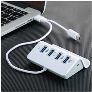 A white USB hub with five ports connected to a laptop, featuring a sleek design and a USB-C cable.