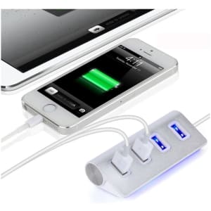 A USB hub in silver with three ports, connected to a smartphone and tablet, on a light background.