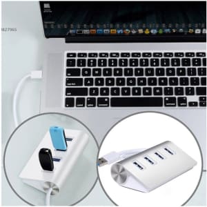 A USB hub in white with four ports, connected to a laptop, featuring various USB devices plugged in.