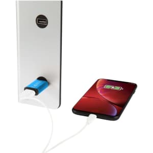 A metal USB data blocker in blue connected to a wall charger, with a phone displaying a charging indicator.