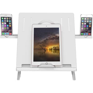 A white foldable laptop stand with slots for a tablet in the centre and two smartphones on the sides.