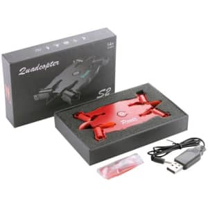 A red foldable drone in a black box, accompanied by a USB charging cable and spare propellers.