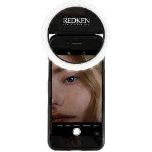 A white Smiley LED selfie light mounted on a smartphone, illuminating a close-up photo of a person's face.