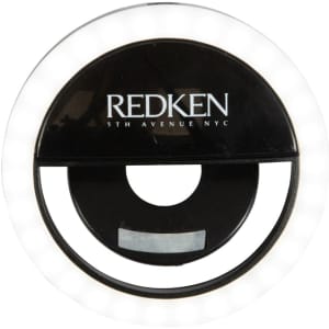A round, black LED selfie light with outer white lights and a central circular opening. It features a logo.