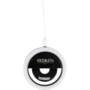 A round, white LED selfie light with a black centre and a white charging cable, featuring a logo.