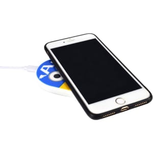 A wireless charger in white and blue with a smartphone placed on top, connected by a charging cable.