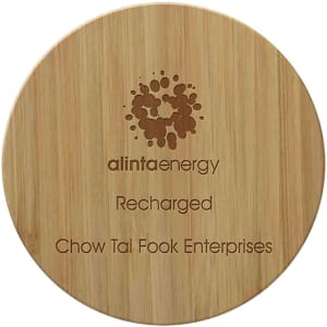 A round bamboo wireless charger with a wooden texture and a logo. It features engraved text.