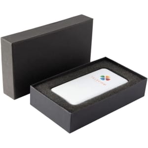 A white power bank with a logo, presented in a black gift box with foam padding.