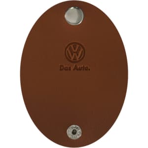 A brown oval-shaped key holder with a metallic button and an embossed logo, featuring the name "Das Auto."