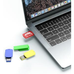 A collection of colourful flash drives—red, green, blue, and yellow—plugged into a laptop's USB port.