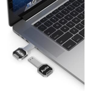A silver Auto LED flash drive plugged into a laptop, featuring a sleek design and a logo.