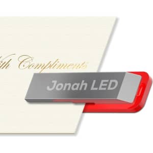 A silver and red LED clip flash drive resting against a cream-coloured card. It features a branding logo.