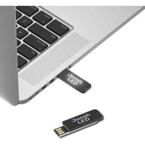 A black Jonah LED clip flash drive partially inserted into a laptop USB port, showcasing its sleek design.
